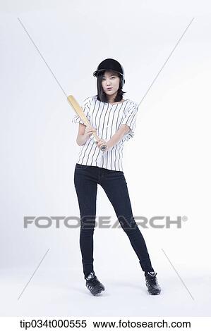Stock Photography - A female baseball player with a bat. Fotosearch
