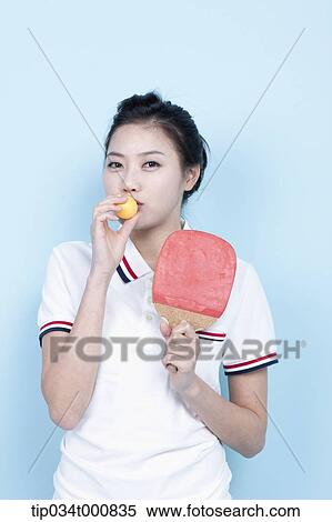 Stock Photography - A female ping-pong player with a ball and racket. Fotosearch