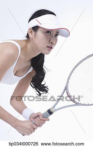 Stock Photograph - A female tennis player holding a racket. Fotosearch