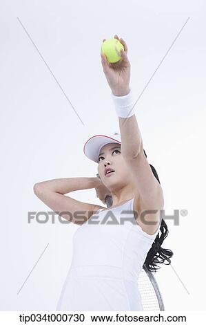 Stock Image - A female tennis player ready for hitting a ball. Fotosearch