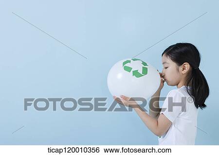 Stock Photograph - A girl blowing a recycling balloon . Fotosearch