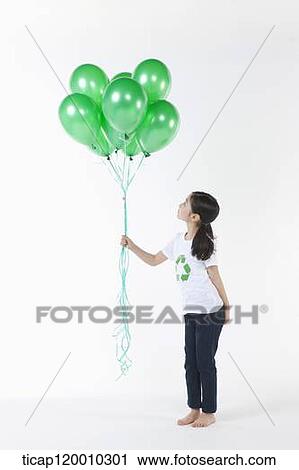 Stock Image - A girl wearing recycling shirt with green balloons. Fotosearch