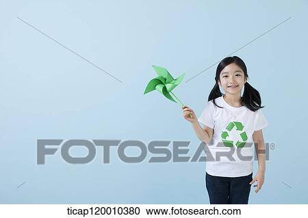 Stock Image - A girl wearing recycling shirt with green pinwheel. Fotosearch