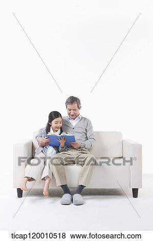 A grandfather and granddaughter reading a book View Large Photo Image Stock Photo - A grandfather and granddaughter reading a book. Fotosearch