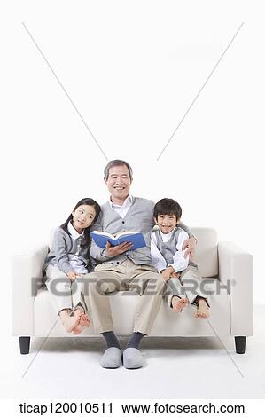 Stock Image - A grandfather and grandsons on the couch . Fotosearch