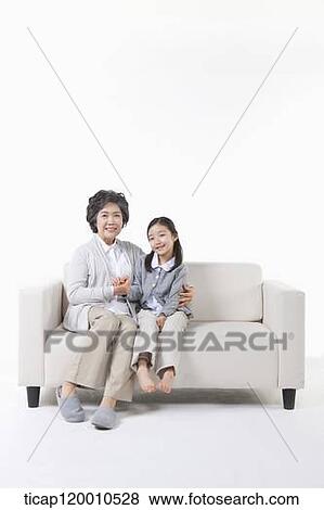 Stock Photo - A grandmother and granddaughter on the couch. Fotosearch