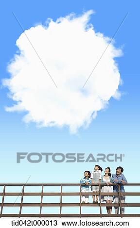 A happy family looking at the blue sky View Large Photo Image Stock Image - A happy family looking at the blue sky . Fotosearch