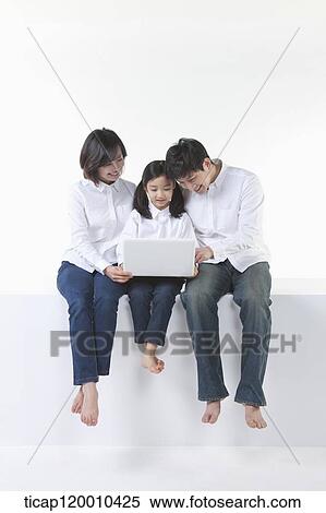 Stock Photography - A happy family looking at the laptop . Fotosearch