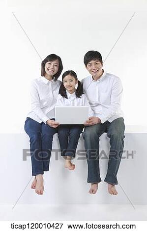 A happy family sitting with the laptop View Large Photo Image Stock Photo - A happy family sitting with the laptop . Fotosearch