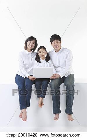 A happy family sitting with the laptop View Large Photo Image Stock Photo - A happy family sitting with the laptop . Fotosearch