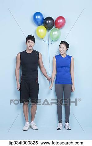 Stock Photography - A jogging man and woman with colorful balloons. Fotosearch