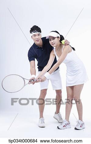 Picture - A male player coaching the female tennis player. Fotosearch