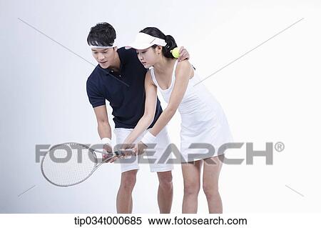 Stock Photography - A male player coaching the female tennis player. Fotosearch