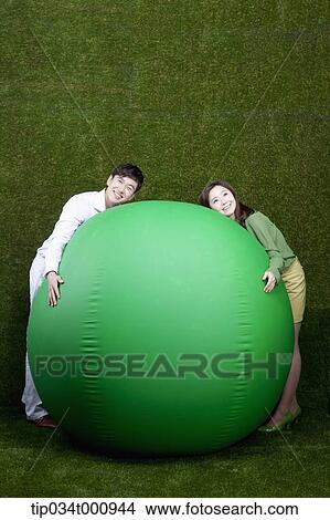 A man and woman resting on a green ball View Large Photo Image Picture - A man and woman resting on a green ball. Fotosearch