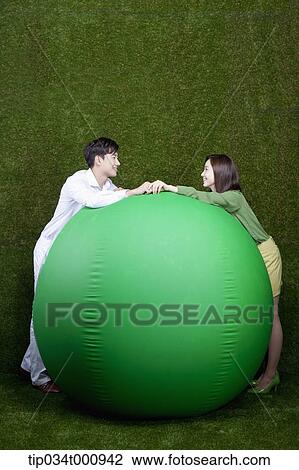 A man and woman resting on a green ball View Large Photo Image Stock Image - A man and woman resting on a green ball. Fotosearch