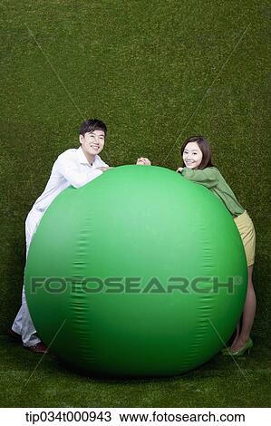 A man and woman resting on a green ball View Large Photo Image Stock Image - A man and woman resting on a green ball. Fotosearch