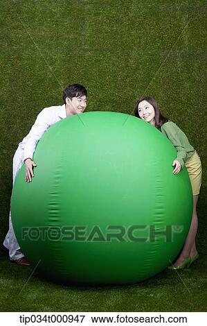 A man and woman resting on a green ball View Large Photo Image Stock Photo - A man and woman resting on a green ball. Fotosearch