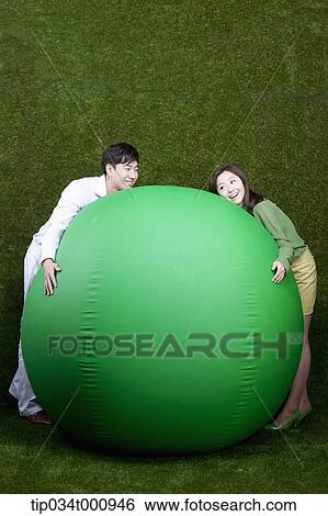 A man and woman resting on a green ball View Large Photo Image Stock Photograph - A man and woman resting on a green ball. Fotosearch