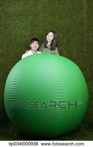 A man and woman with a green ball View Large Photo Image Stock Photograph - A man and woman with a green ball. Fotosearch