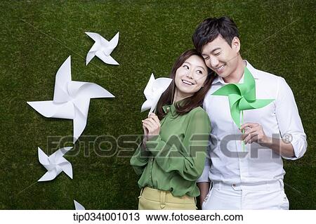 Stock Image - A man and woman with green and white pinwheels. Fotosearch