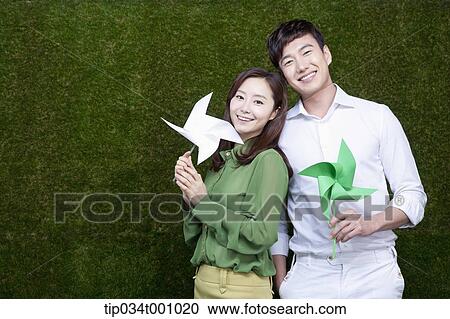 Stock Image - A man and woman with green and white pinwheels. Fotosearch