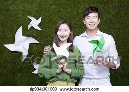 Stock Photo - A man and woman with green and white pinwheels. Fotosearch