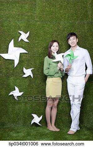 Stock Photograph - A man and woman with green and white pinwheels. Fotosearch