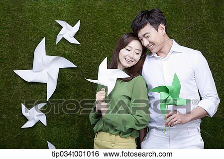 Stock Photograph - A man and woman with green and white pinwheels. Fotosearch