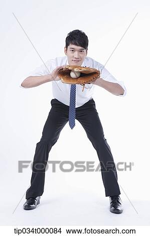 Picture - A man catching a baseball with a glove. Fotosearch