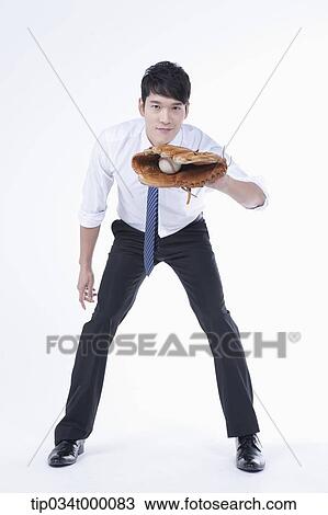 Stock Image - A man catching a baseball with a glove. Fotosearch