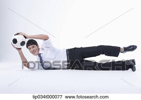 Stock Photo - A man catching a soccer ball. Fotosearch