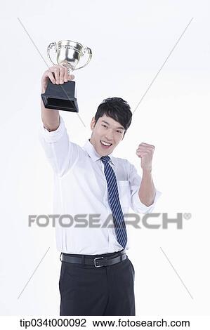 Stock Image - A man excited with a trophy. Fotosearch