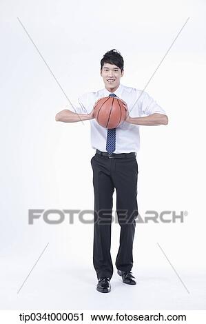 Stock Image - A man holding a basketball. Fotosearch