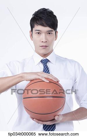 Stock Photography - A man holding a basketball. Fotosearch