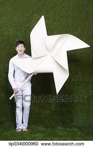 A man holding a white pinwheel View Large Photo Image Stock Image - A man holding a white pinwheel. Fotosearch