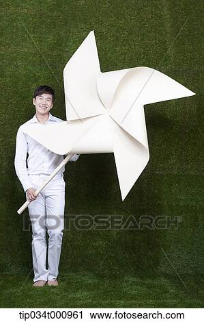 A man holding a white pinwheel View Large Photo Image Stock Image - A man holding a white pinwheel. Fotosearch