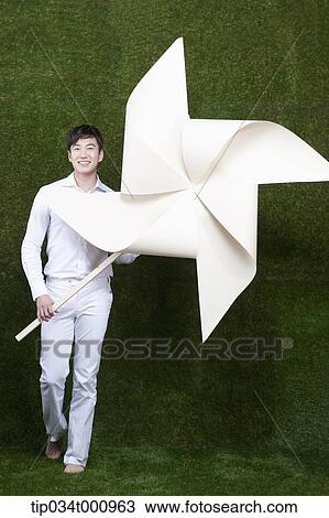 Stock Image - A man holding a white pinwheel. Fotosearch