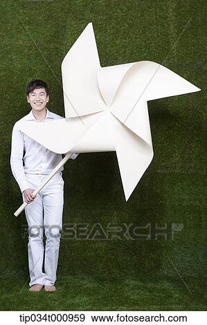 A man holding a white pinwheel View Large Photo Image Stock Photo - A man holding a white pinwheel. Fotosearch