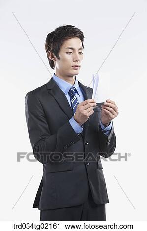 A man holding the folded paper View Large Photo Image Stock Image - A man holding the folded paper. Fotosearch