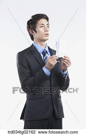 A man holding the folded paper View Large Photo Image Stock Image - A man holding the folded paper. Fotosearch