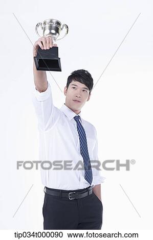 A man holding up a trophy View Large Photo Image Stock Image - A man holding up a trophy. Fotosearch