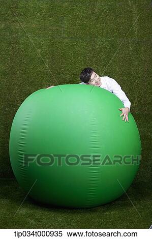 A man hugging a green ball View Large Photo Image Stock Photography - A man hugging a green ball. Fotosearch