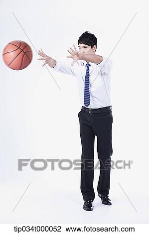 Stock Image - A man passing a basketball. Fotosearch