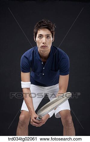 Stock Image - A man playing tennis. Fotosearch