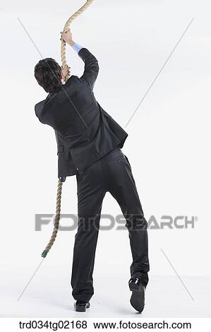 Stock Photo - A man pulling the rope . Fotosearch