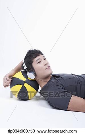 A man resting on the basketball with the headset on View Large Photo Image Stock Image - A man resting on the basketball with the headset on . Fotosearch
