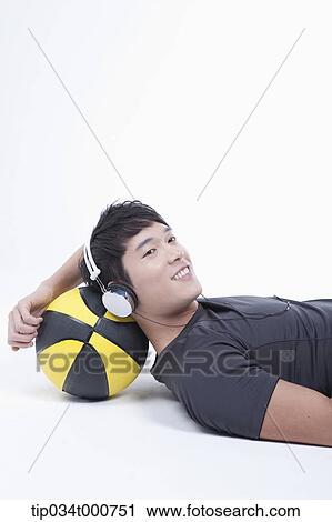 A man resting on the basketball with the headset on View Large Photo Image Stock Image - A man resting on the basketball with the headset on . Fotosearch