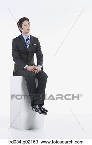 Stock Image - A man sitting on the box. Fotosearch