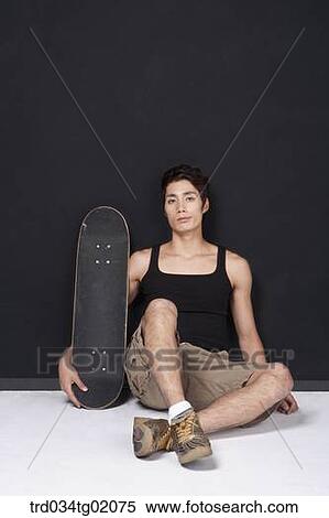 A man sitting with a skateboard View Large Photo Image Stock Photography - A man sitting with a skateboard. Fotosearch