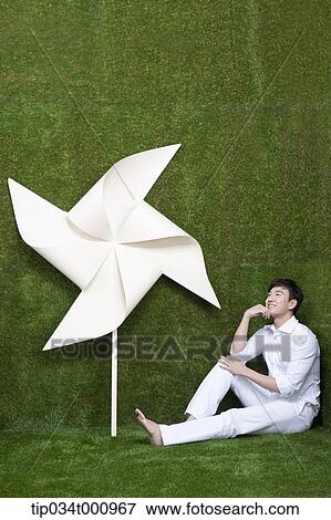 A man sitting with a white pinwheel View Large Photo Image Stock Photo - A man sitting with a white pinwheel. Fotosearch